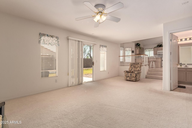 empty room featuring carpet flooring, a ceiling fan, and a sink