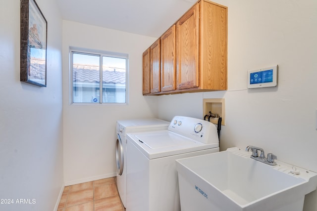 laundry area featuring washer and dryer, light tile patterned flooring, cabinets, and sink