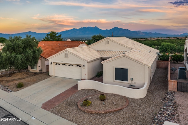 view of front of house featuring a mountain view, cooling unit, and a garage