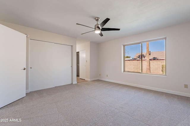 unfurnished bedroom featuring ceiling fan, light colored carpet, and a closet