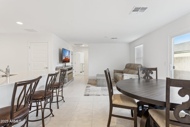 dining space featuring sink and light tile patterned flooring