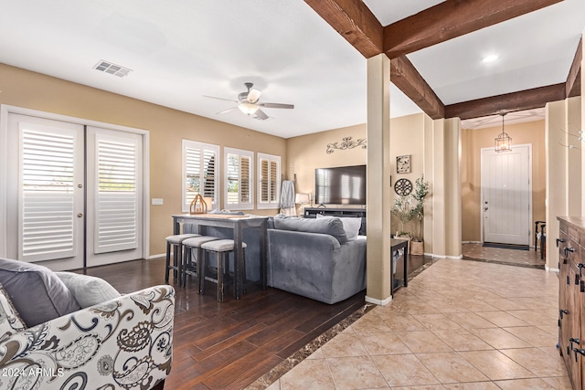 living room with beam ceiling, ceiling fan, and hardwood / wood-style flooring