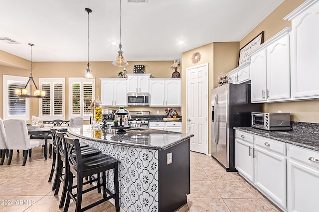 kitchen featuring pendant lighting, light tile patterned flooring, white cabinetry, appliances with stainless steel finishes, and a notable chandelier