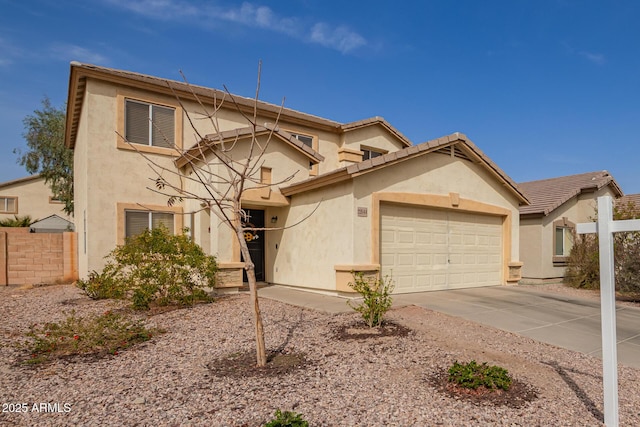 traditional-style house with an attached garage, fence, concrete driveway, and stucco siding