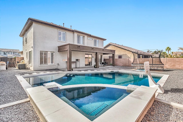 back of house with a patio, a fenced in pool, and a trampoline