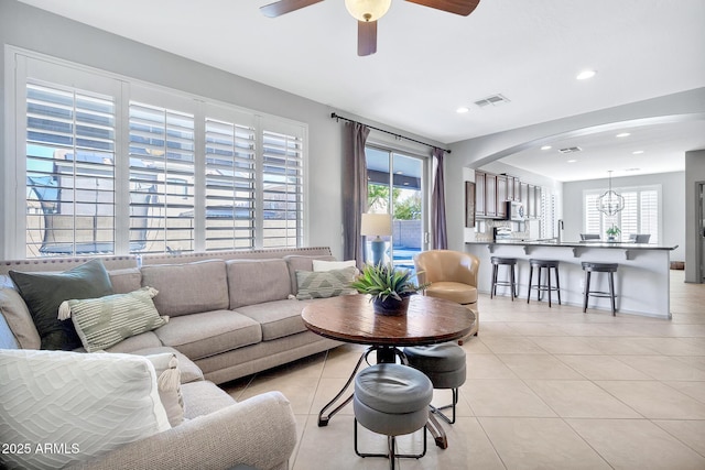 living room featuring a healthy amount of sunlight, light tile patterned floors, and ceiling fan