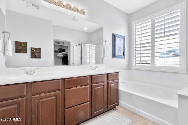 bathroom featuring tile patterned flooring, vanity, and plus walk in shower