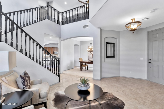 tiled entryway featuring a towering ceiling