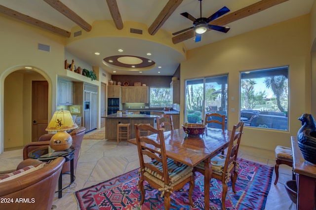 dining space featuring ceiling fan, beam ceiling, and high vaulted ceiling