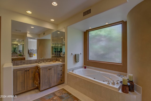 bathroom featuring tile patterned floors, vanity, and a relaxing tiled tub