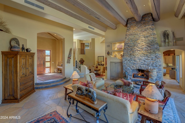 living room featuring beamed ceiling and a fireplace