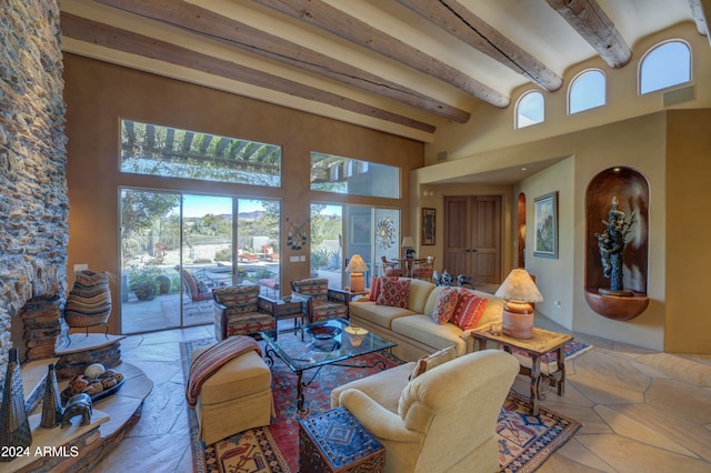 living room featuring beam ceiling and a high ceiling