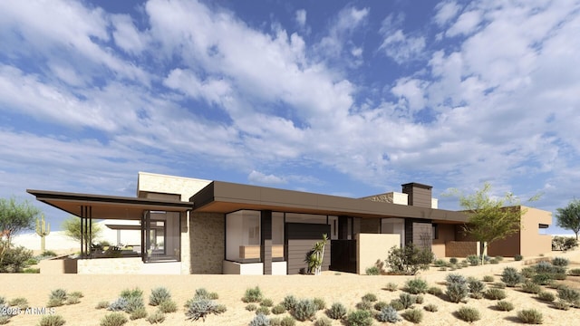 view of front of property featuring a chimney, an attached garage, and stucco siding