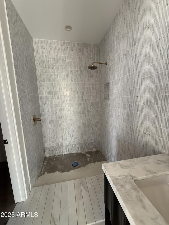 8167 E Leaning Rock Rd Unit 193, Scottsdale, AZ 85266 - full bathroom with a tile shower, wood finished floors, vanity, and tile walls