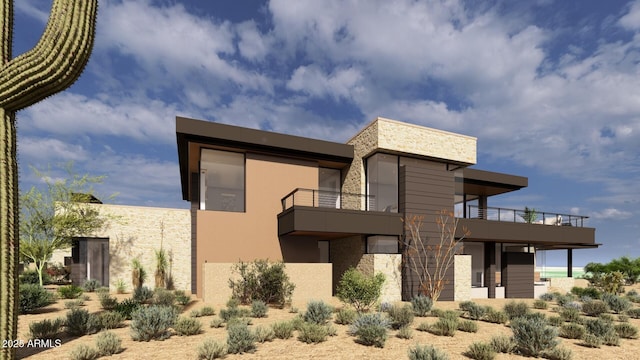 rear view of property with stone siding, a balcony, and stucco siding