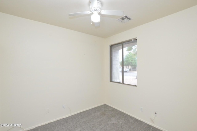 carpeted spare room featuring ceiling fan