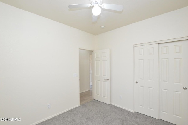 unfurnished bedroom featuring ceiling fan, a closet, and light colored carpet