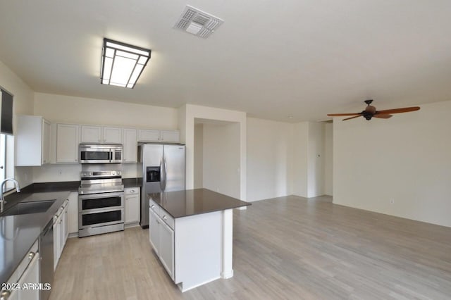 kitchen with a center island, sink, white cabinets, and stainless steel appliances