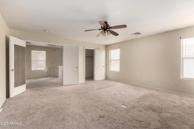 unfurnished bedroom featuring light carpet, ceiling fan, and a closet