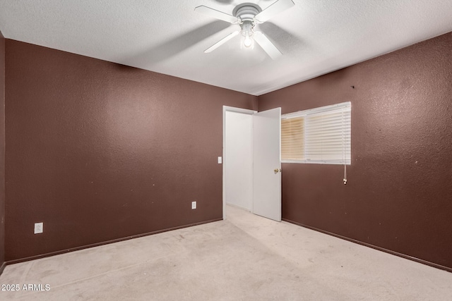 unfurnished bedroom with a textured wall, carpet flooring, a ceiling fan, and a textured ceiling