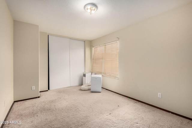 unfurnished bedroom featuring carpet floors, a closet, and baseboards