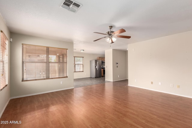 unfurnished room with ceiling fan, wood finished floors, and baseboards