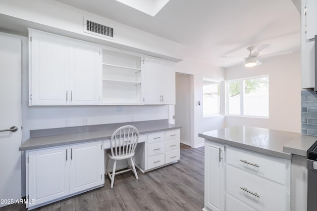 home office featuring light hardwood / wood-style floors, ceiling fan, and built in desk