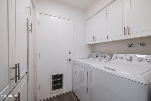 clothes washing area with cabinets, washing machine and dryer, and dark hardwood / wood-style flooring