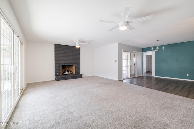 unfurnished living room with ceiling fan, a brick fireplace, and carpet floors