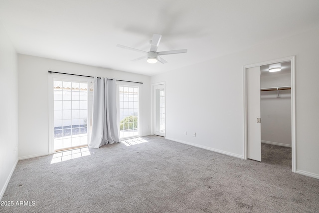 unfurnished bedroom with light carpet, ceiling fan, access to exterior, a walk in closet, and a closet