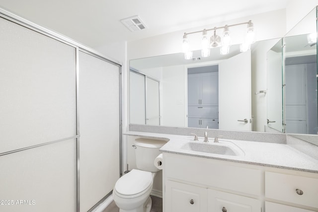 bathroom featuring vanity, toilet, and walk in shower