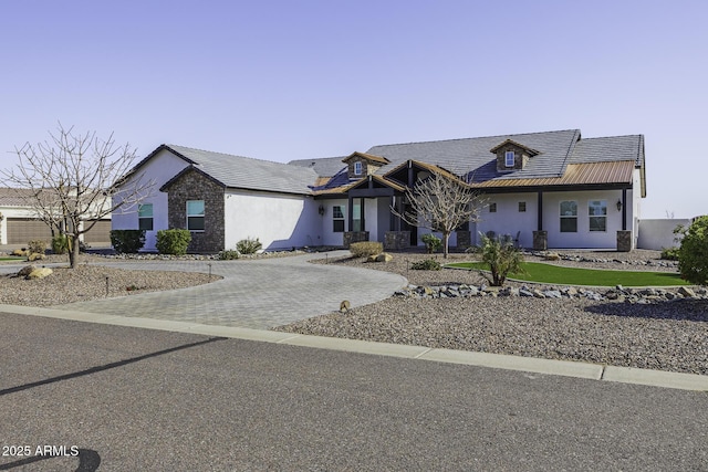 view of front facade with decorative driveway and stucco siding