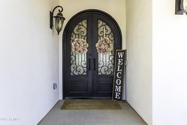 property entrance with stucco siding and french doors