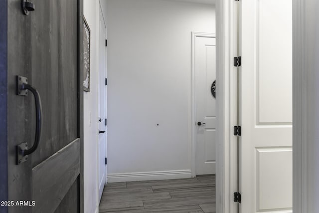 hallway with wood finished floors and baseboards