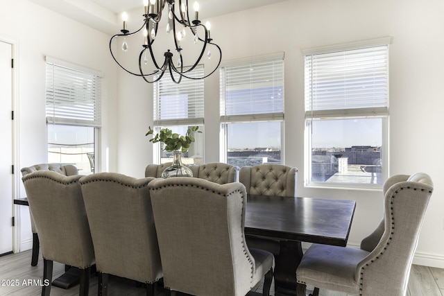 dining area featuring a wealth of natural light, baseboards, a chandelier, and light wood finished floors