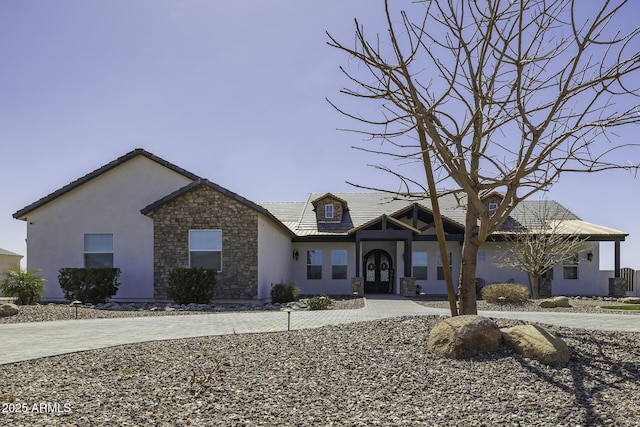 view of front of house featuring french doors, stone siding, and stucco siding