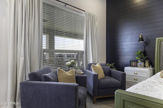 bedroom with wooden walls and light wood-style floors