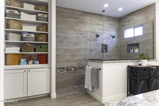 bathroom with recessed lighting, wood finished floors, and a walk in shower