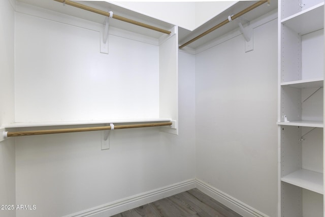 walk in closet with wood finished floors