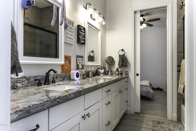 bathroom with double vanity, wood finished floors, ensuite bathroom, and a sink