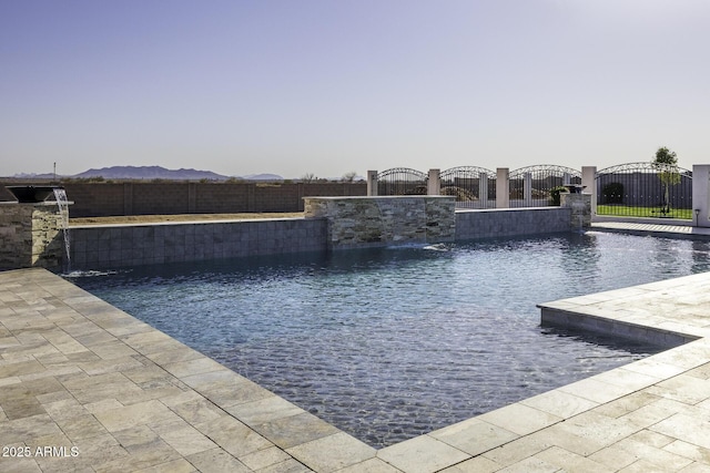 view of pool with a mountain view, a gate, fence private yard, and a fenced in pool