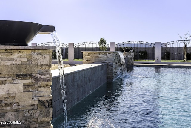 exterior space with a water view and fence