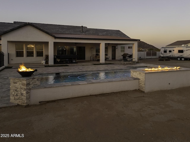 outdoor pool with a patio, a fire pit, and fence