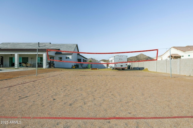 view of community featuring fence and volleyball court