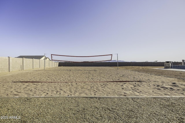 view of home's community featuring volleyball court and fence