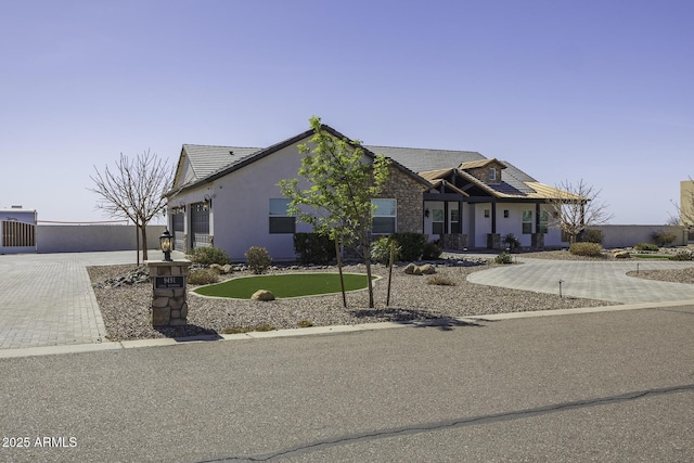 view of front of home with decorative driveway, a garage, stucco siding, and a tile roof