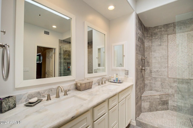 bathroom featuring tiled shower and vanity