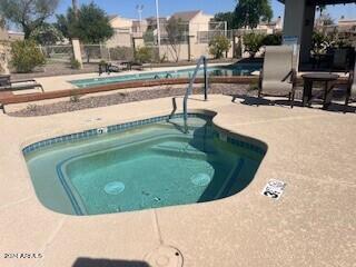 view of swimming pool featuring a patio and a hot tub