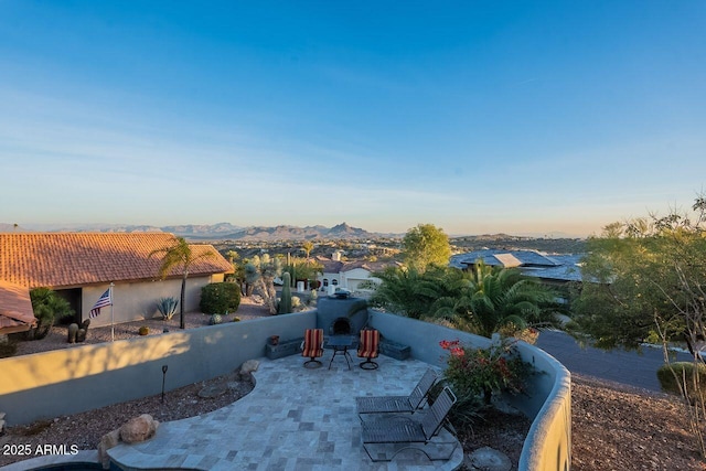 patio terrace at dusk featuring a mountain view