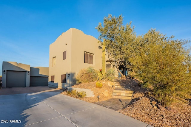 pueblo revival-style home with a garage